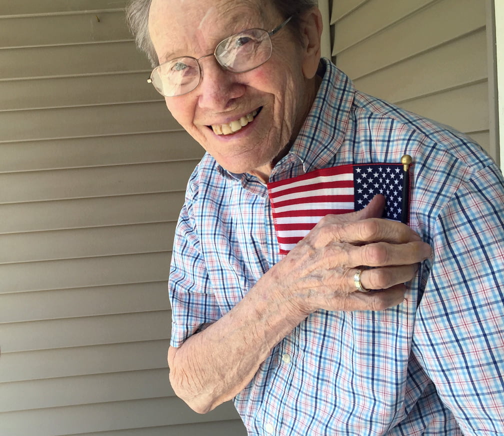 Veteran smiling with small American flag in his front shirt pocket
